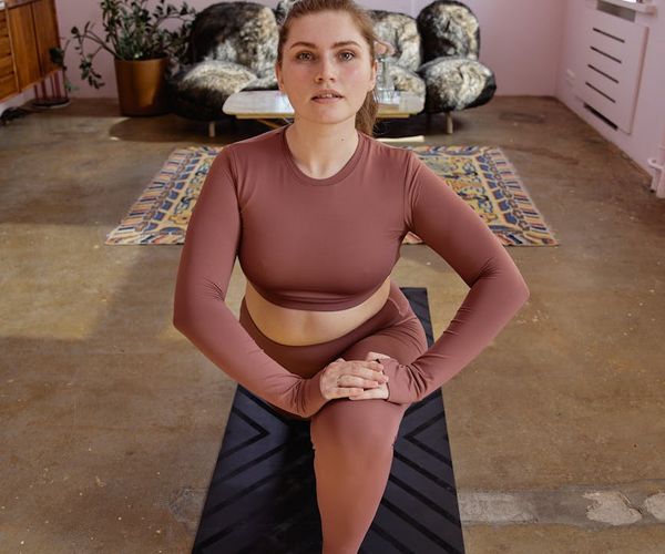 A cozy corner of a room with a yoga mat and a plant, suggesting a daily routine.
